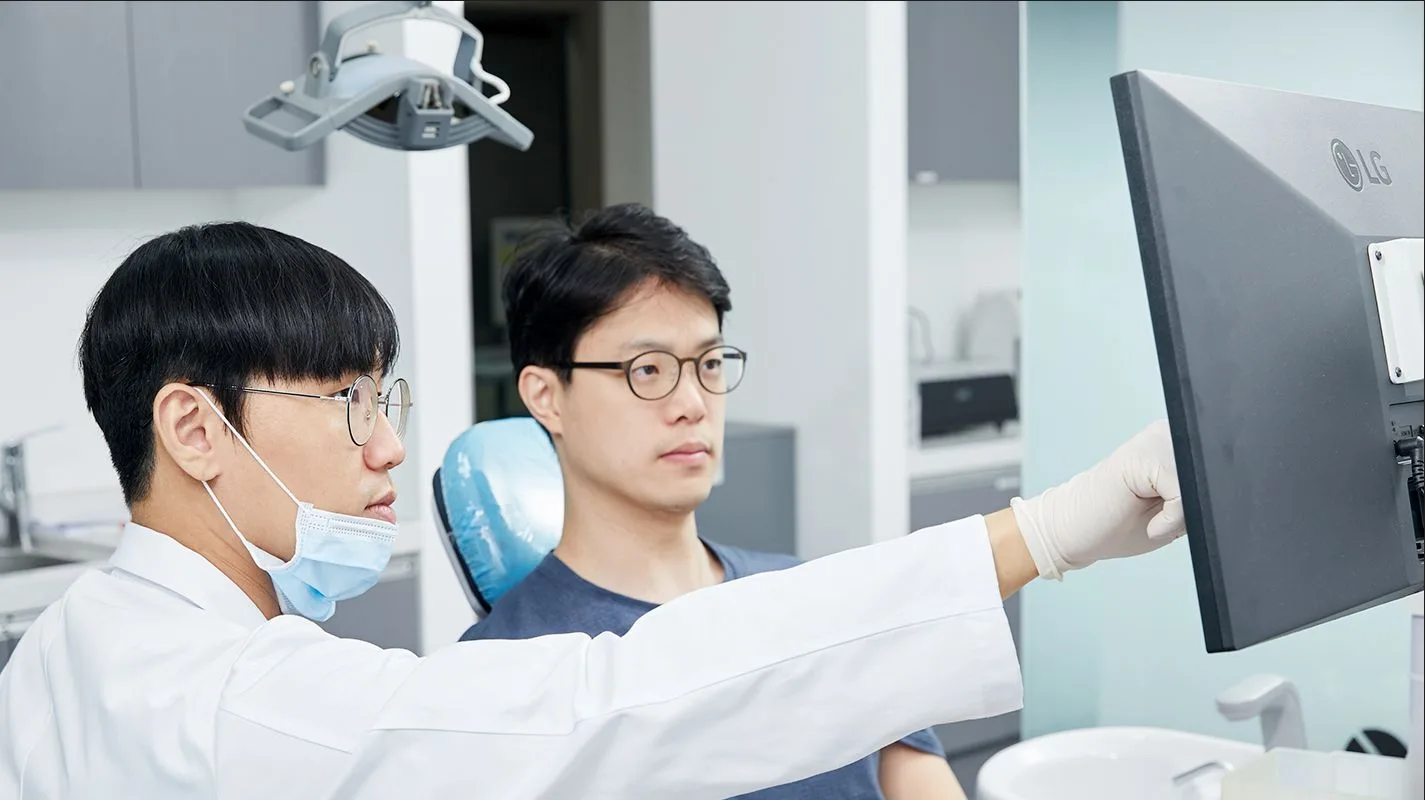 서울원플란트치과 의료진이 모니터의 3D 영상 자료를 보며 치료 계획을 설명하는 모습